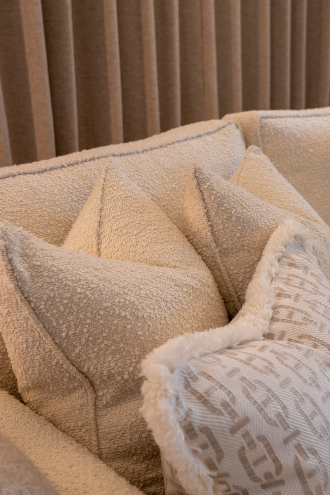 Close-up of textured pillows on a sofa with a neutral background