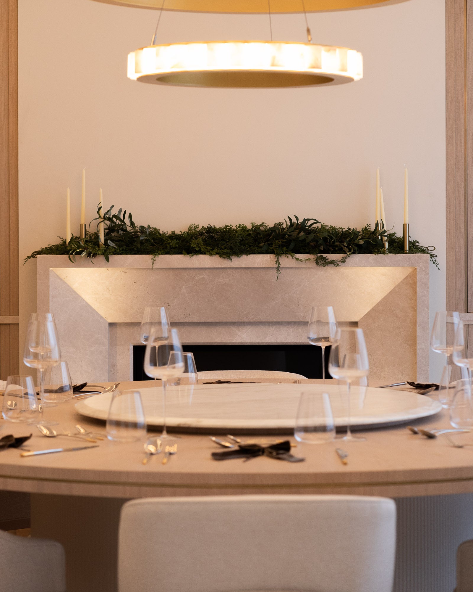 Luxury dining room with bespoke round dining table, feature fireplace and statement lighting.