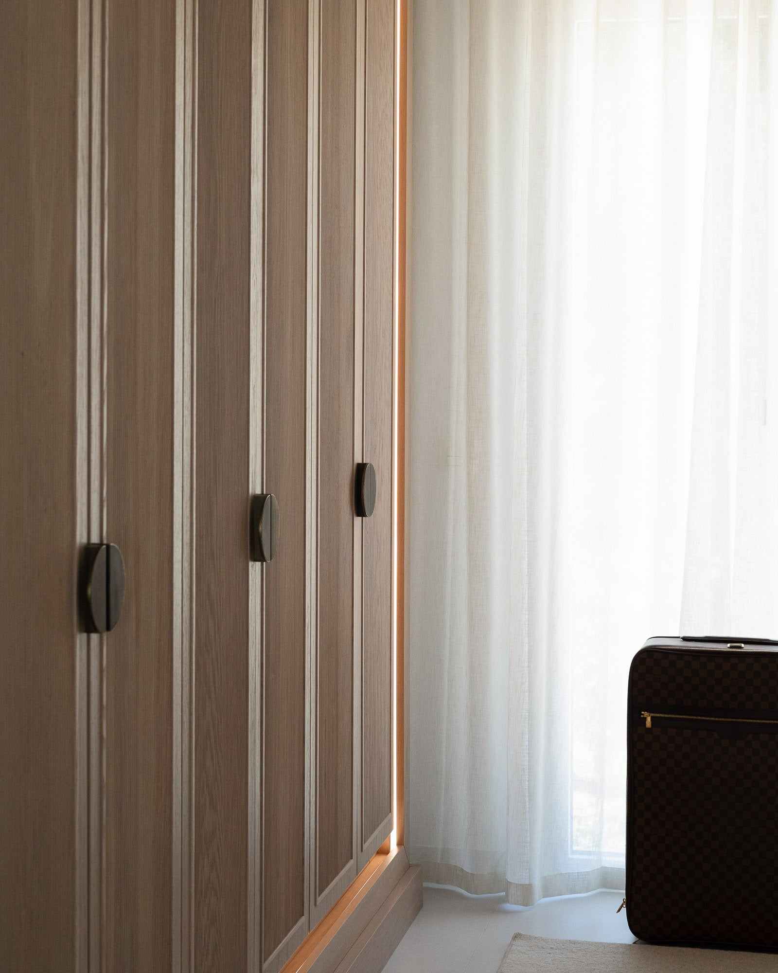 Bespoke oak wardrobe with fluted detailing and integrated lighting.