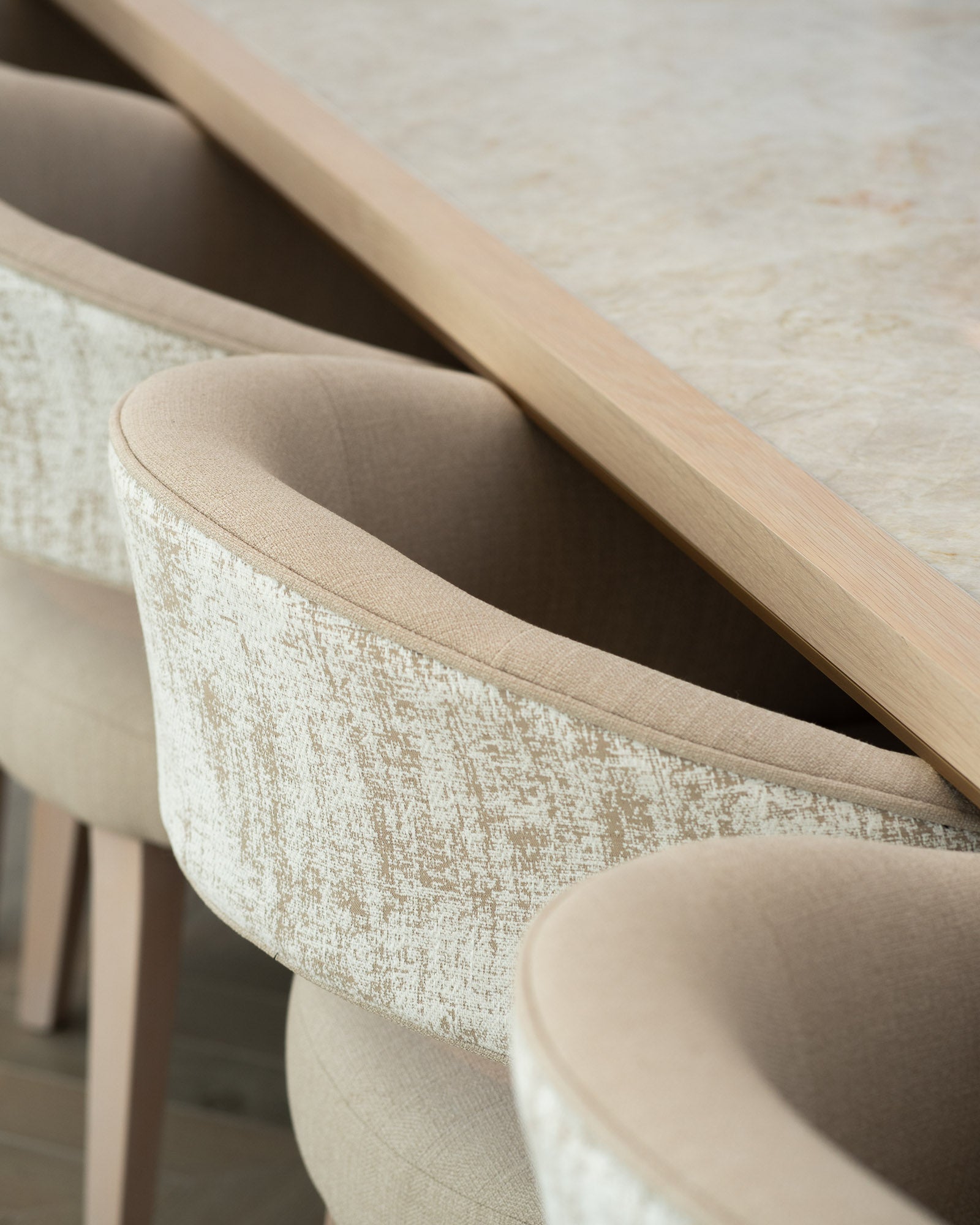 Curved upholstered dining chairs surrounding a bespoke oak dining table.