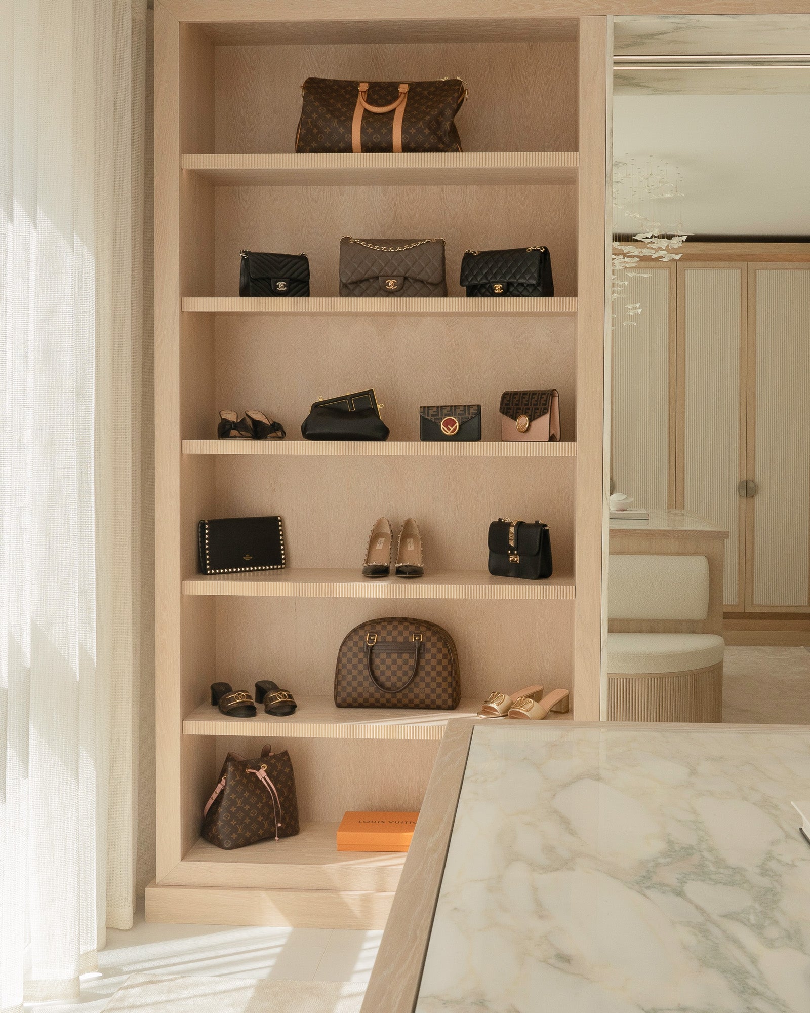 Bespoke illuminated shelving displaying decorative objects within a luxury interior.