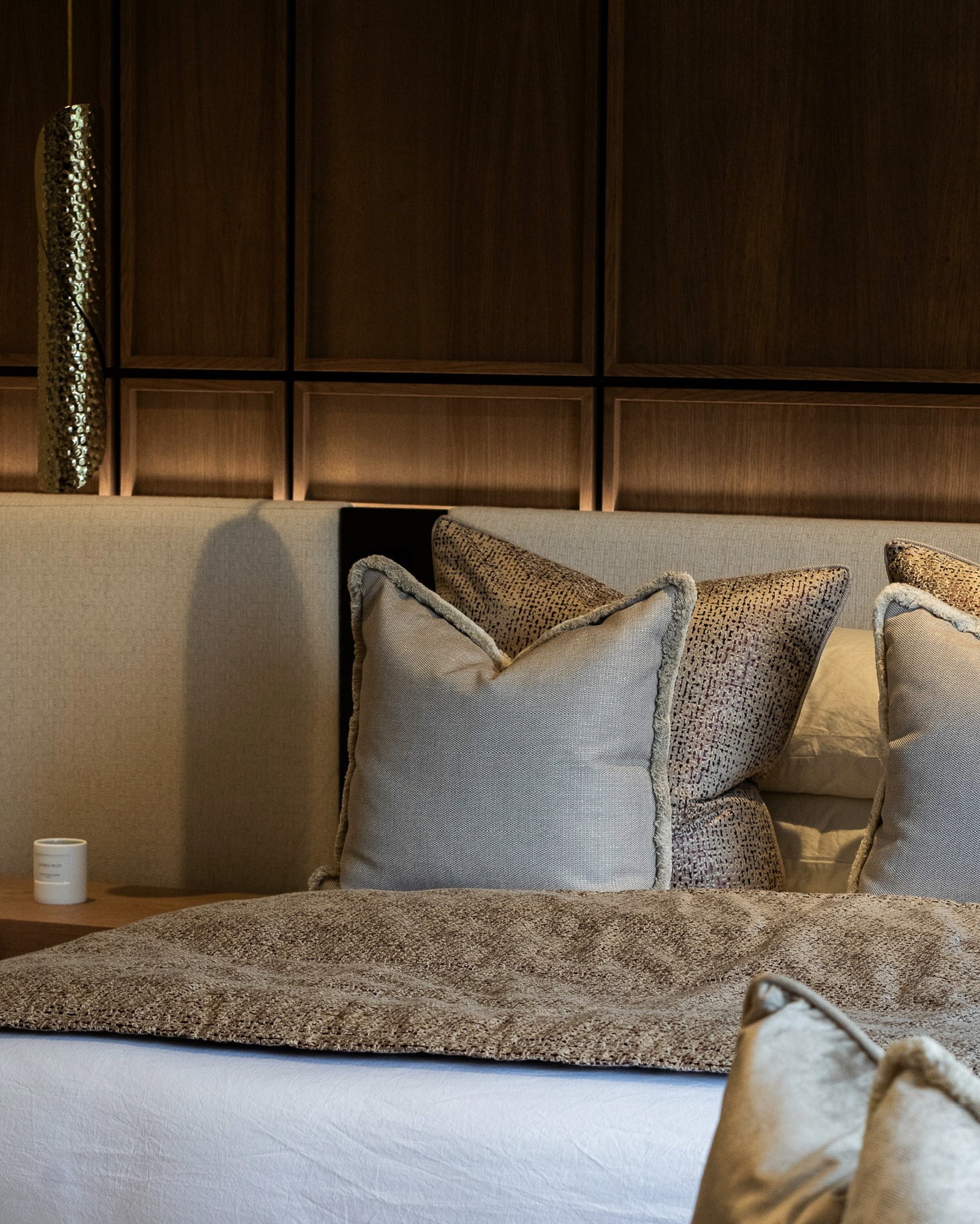 Luxury bedroom featuring bespoke upholstered headboard and walnut wall panelling