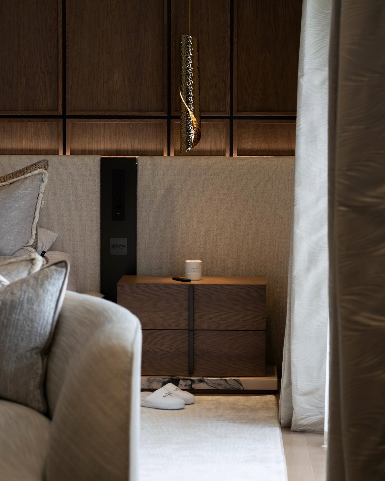 Contemporary bedroom with bespoke bedside furniture and walnut wall panelling