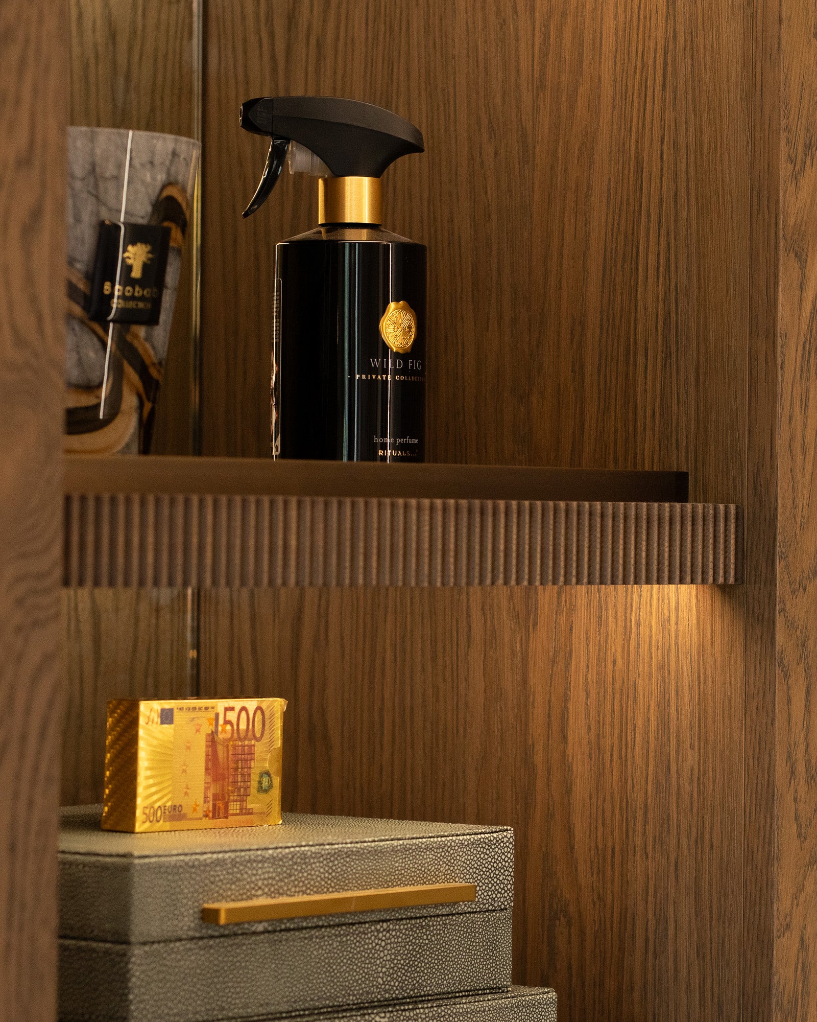 Luxury dressing room shelving with bespoke walnut joinery and integrated lighting