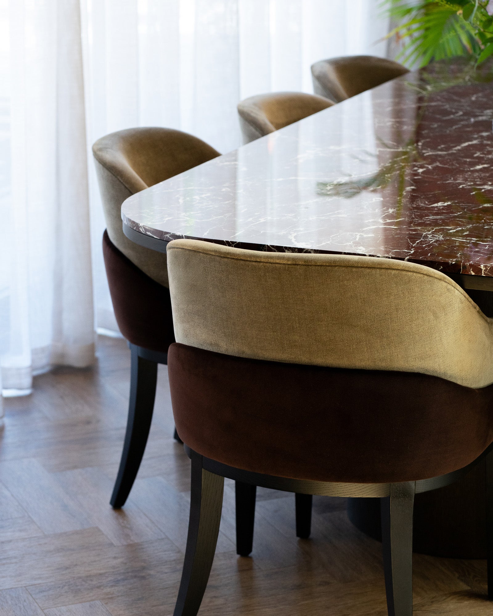 Luxury dining area featuring Rosso Levanto marble dining table and upholstered chairs
