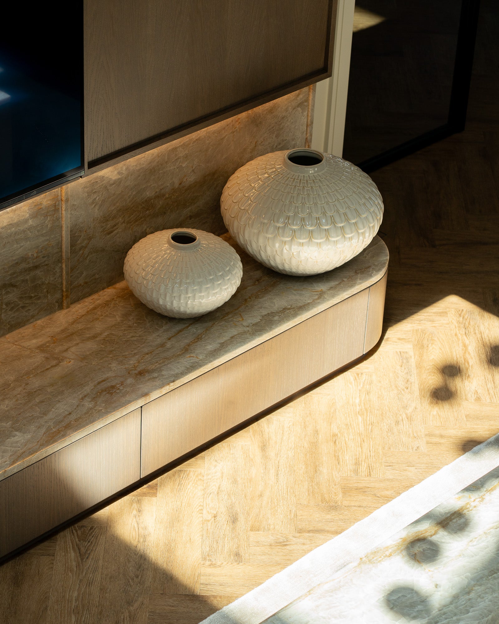 Bespoke media unit with natural stone surfaces and decorative ceramic accessories