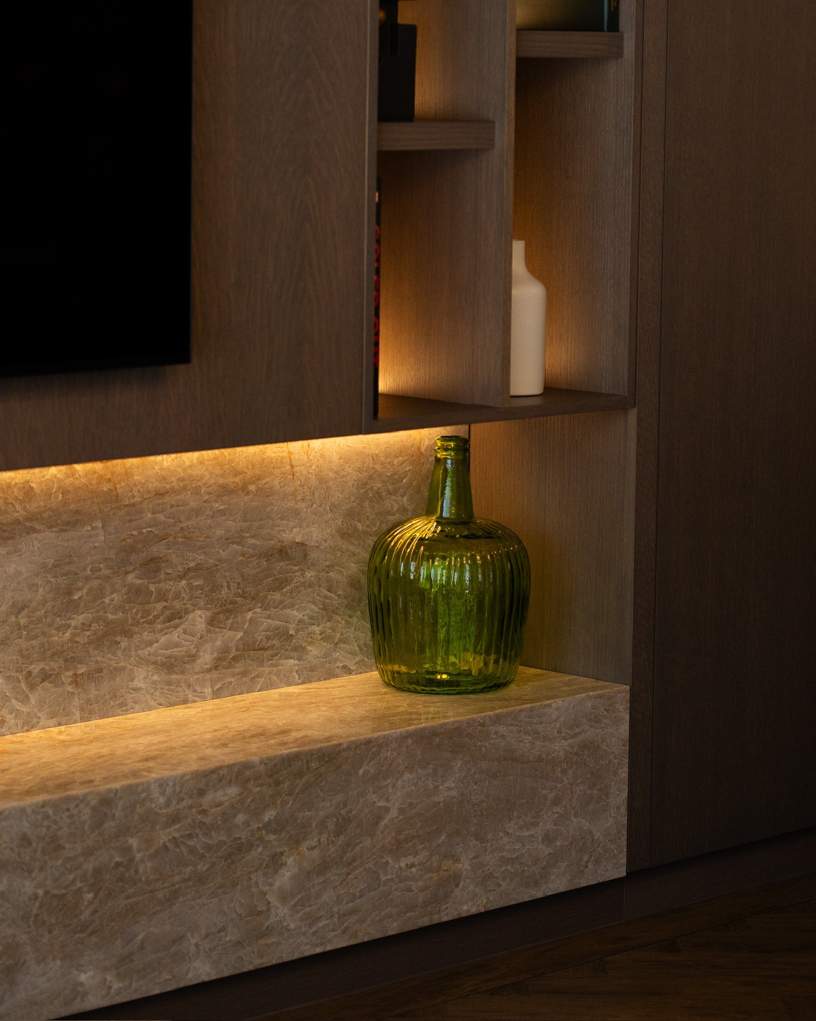 Detail of bespoke media wall with stone shelving and integrated lighting at The Sevenoaks Residence